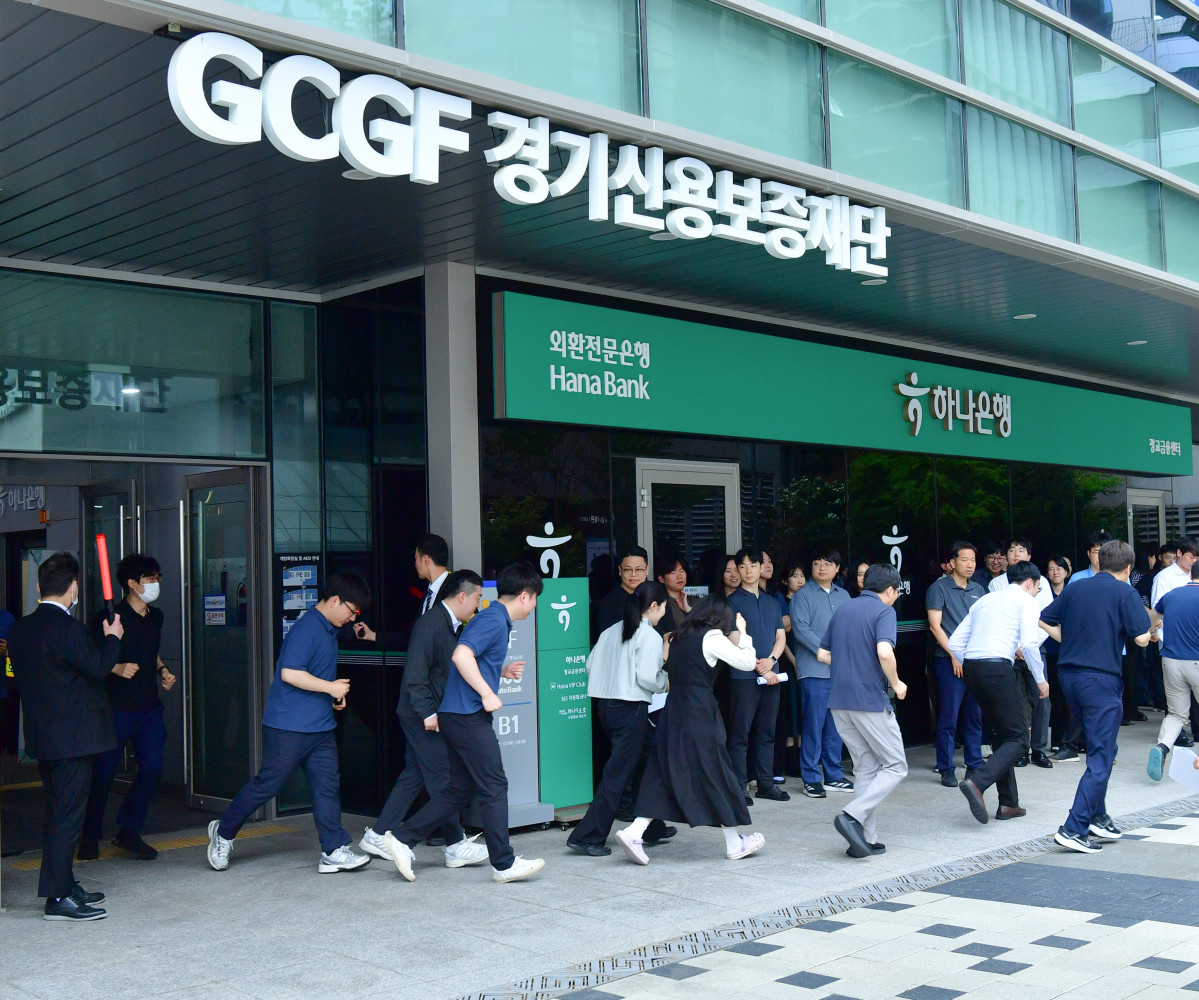 ▲경기신용보증재단이 21일 본점에서 실시한 상반기 소방훈련에서 임직원과 입주기관 관계자들이 비상대피훈련을 진행하며 건물 밖으로 신속하게 이동하고 있다. (경기신용보증재단)