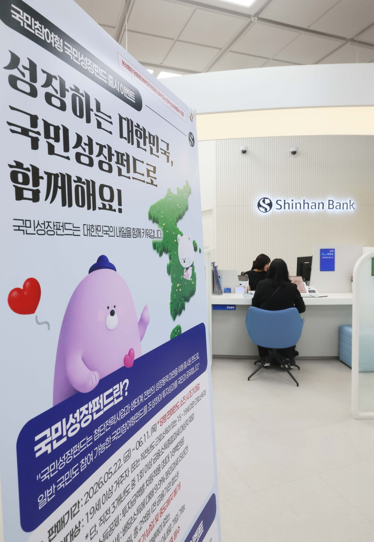 ▲국민 자금으로 반도체·이차전지 등 첨단전략산업에 투자하고 그 성과를 함께 나누는 ‘국민참여형 국민성장펀드’ 출시를 하루 앞둔 21일 서울 중구 신한은행 본점 영업부에 관련 안내문이 게시돼 있다. 올해 국민 대상 모금액은 총 6000억원 규모로, 6월 11일까지 3주간 선착순 판매된다. 주요은행 10개사와 증권사 15개사 영업점을 직접 방문하거나 온라인으로 신청할 수 있다. 투자한도는 전용계좌 기준 1인당 연간 1억원, 5년간 최대 2억원이다. 국민성장펀드는 국민 돈을 모아 여러 운용사에 나눠 투자하는 방식으로 설계됐는데, 각 자펀드에서 손실이 발생했을 때 정부 재정이 20% 범위 안에서 먼저 손실을 부담한다. 전용계좌로 가입해 3년간 유지하면 최대 40% 소득공제 등 세제혜택을 받을 수 있다. 신태현 기자 holjjak@
