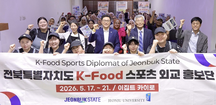 ▲홍보를 마친 뒤 관계자들과 현지 참가자들이 전북 K-Food 스포츠 외교 홍보단 현수막을 앞세워 주먹을 쥐어 보이며 화이팅을 외치고 있는 모습이다. (사진제공=전북특별자치도)