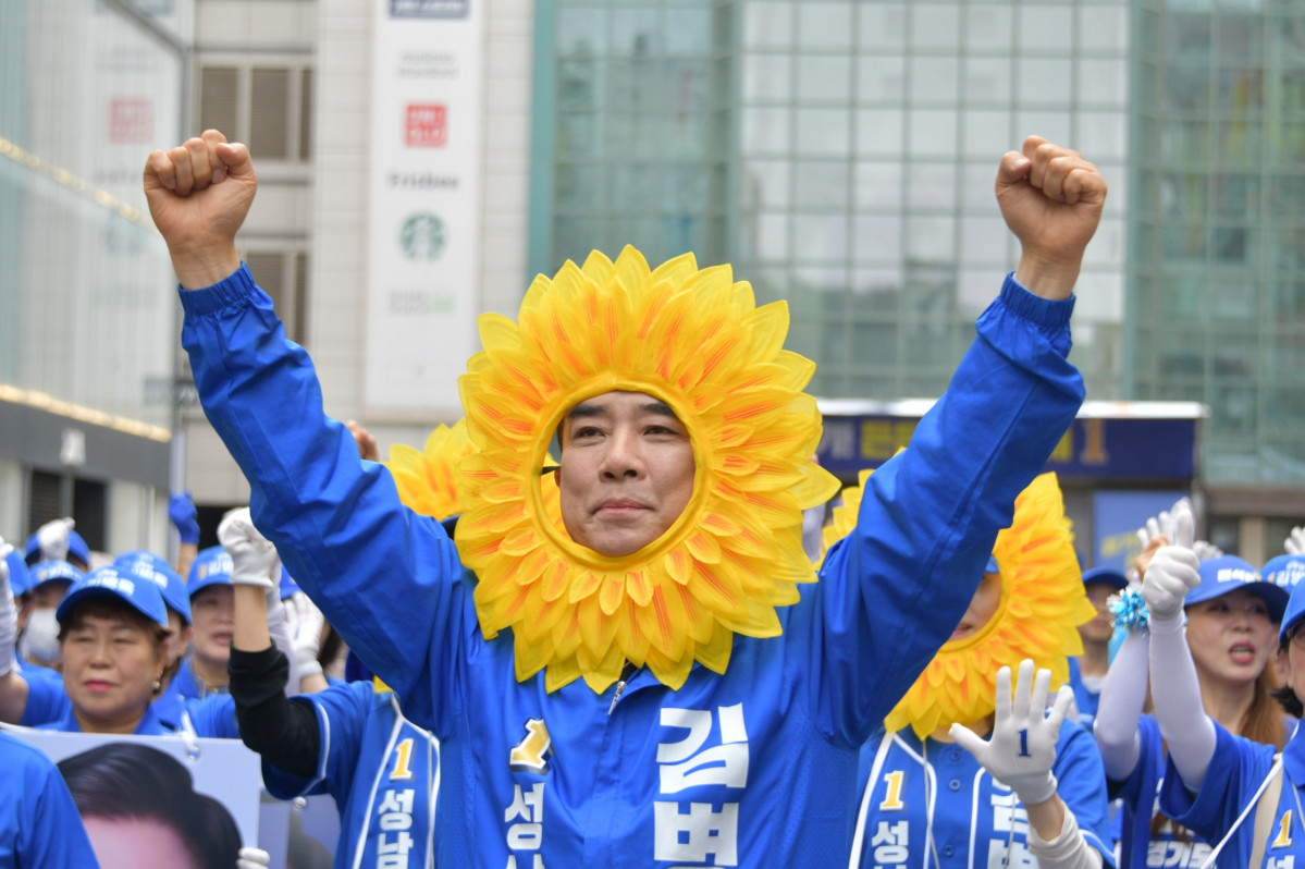 ▲김병욱 더불어민주당 성남시장 후보가 해바라기 소품을 쓰고 지지자들과 함께 거리유세를 펼치며 두 주먹을 들어 올리고 있다. (김병욱 후보 캠프)