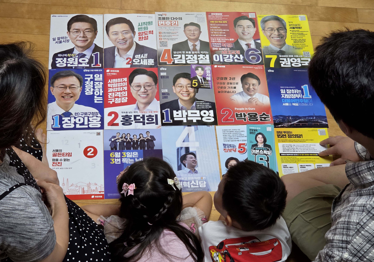 ▲6·3 지방선거를 9일 앞둔 25일 서울 구로구의 한 주택에서 가족이 지방선거 공보물을 살펴보고 있다. 신태현 기자 holjjak@
