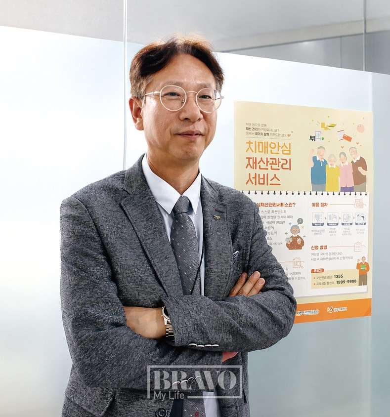 ▲정순희 국민연금 재산관리지원추진단장이 국민연금공단 본사 사무실에 배치된 치매안심재산관리서비스 포스터 앞에서 포즈를 취하고 있다. 서지희 기자 jhsseo@