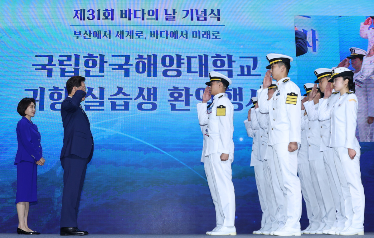 ▲이재명 대통령이 27일 부산 영도구에서 열린 제31회 바다의 날 기념식에서 해양대 실습생의 귀항 보고를 받고 있다. (연합뉴스)