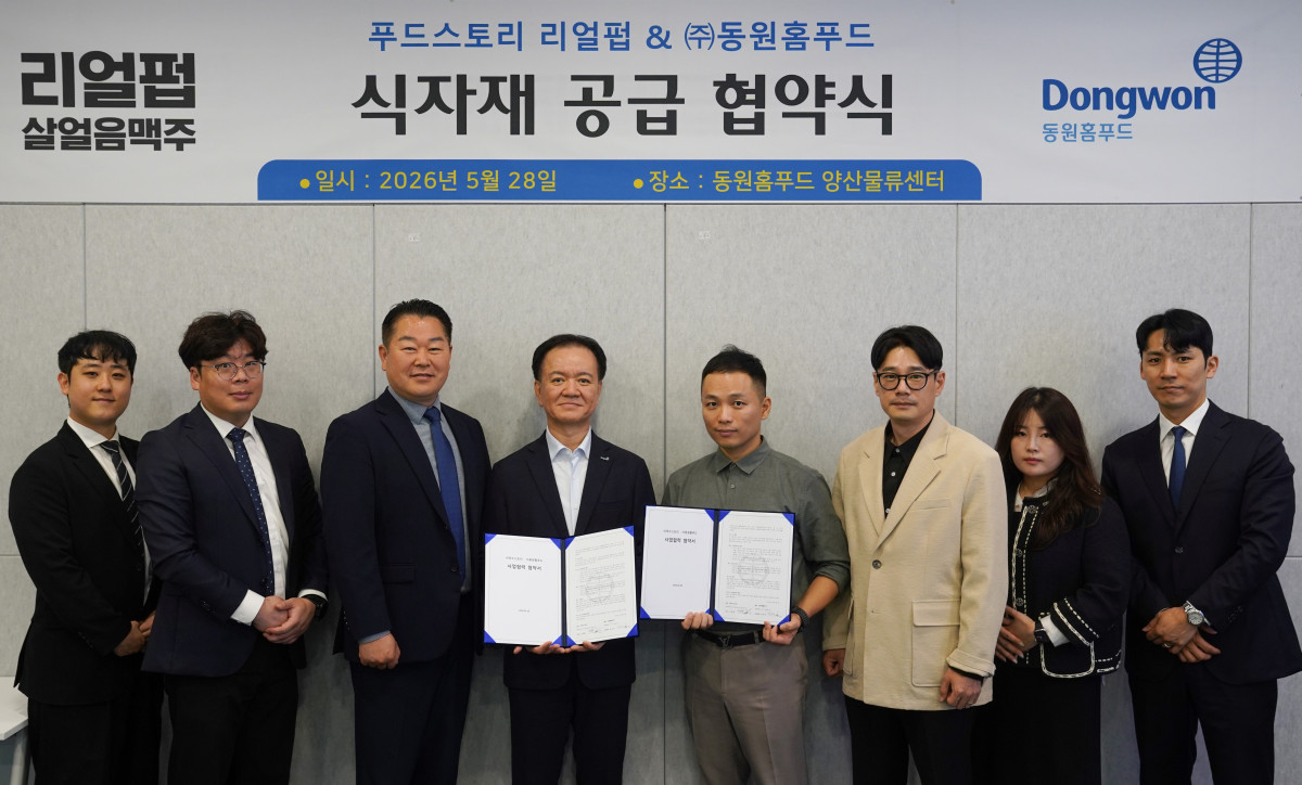 ▲박상천 동원홈푸드 외식식재사업부장(왼쪽 네 번째)과 구희동 푸드스토리 대표(왼쪽에서 다섯 번째)가 28일 양산물류센터에서 업무 협약을 맺고 기념 촬영을 하고 있다. (사진제공=동원홈푸드)