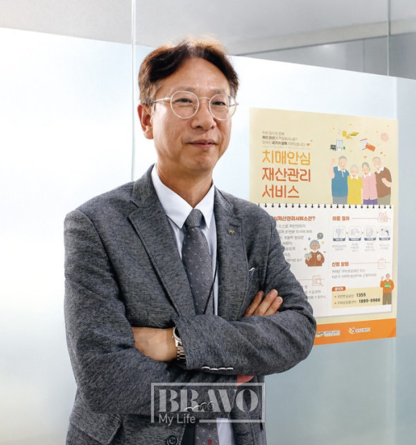 ▲정순희 국민연금 재산관리지원추진단장이 국민연금공단 본사 사무실에 배치된 치매안심재산관리서비스 포스터 앞에서 포즈를 취하고 있다. 서지희 기자 jhsseo@