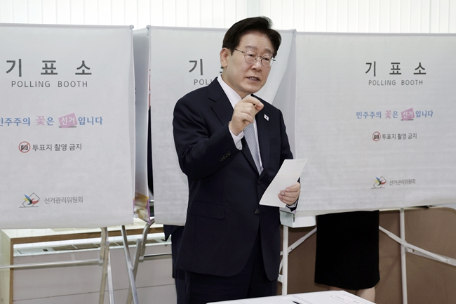 ▲이재명 대통령이 제9회 전국동시지방선거 사전투표 첫날인 29일 서울 종로구 삼청동 주민센터에서 사전 투표 중 기표 도장 관련 문의를 하고 있다. (연합뉴스)