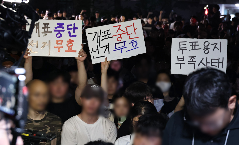 ▲4일 제9회 전국동시지방선거 및 국회의원 재·보궐선거 투표용지 부족으로 투표 시간이 오후 10시까지 연장됐던 서울 송파구 잠실7동 제2투표소 앞에서 '부정선거' 등 손팻말을 든 시민들이 구호를 외치고 있다. (연합뉴스)
