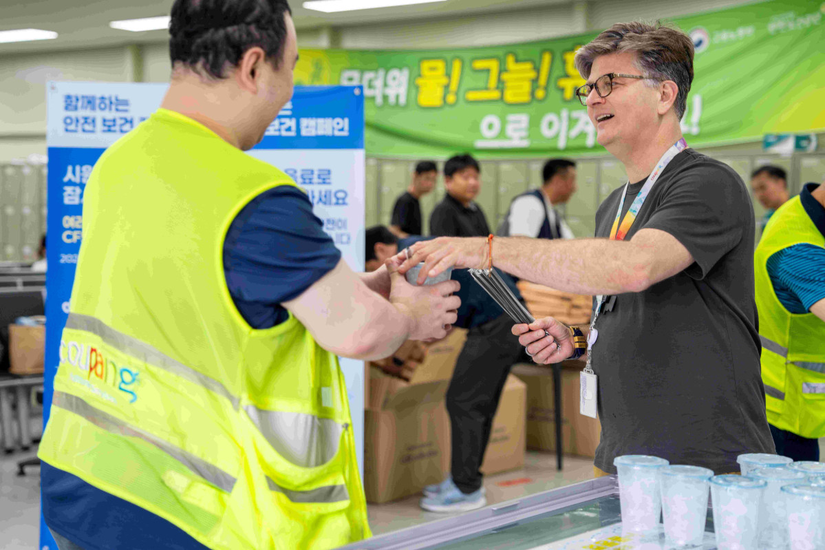 ▲라이언 브라운(오른쪽) 쿠팡풀필먼트서비스 대표가 지난 4일 고양1센터에서 직원들에게 얼음 음료를 건네며 격려하고 있다. (사진제공=쿠팡풀필먼트서비스)