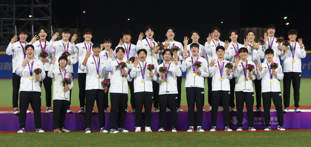 ▲2023년 10월 7일 중국 사오싱 야구장 1구장에서 열린 2022 항저우 아시안게임 남자 야구 시상식에서 금메달을 목에 걸며 아시안게임 4연패를 달성한 한국 야구 대표팀이 손가락 네개를 펴 보이며 기념촬영 하고 있다. 윗줄 왼쪽부터 원태인, 윤동희, 최지민, 박영현, 김지찬, 강백호, 문동주, 곽빈, 김혜성, 나균안, 박성한, 최지훈, 김영규, 박세웅. 아랫줄 왼쪽부터 김형준, 김성윤, 정우영, 노시환, 문보경, 고우석, 장현석, 김주원, 김동헌, 최원준. (뉴시스)
