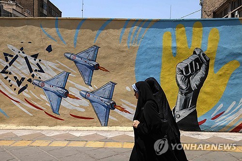 ▲테헤란 거리의 반미 반이스라엘 벽화 앞을 지나는 여성들.(AFP/연합뉴스)