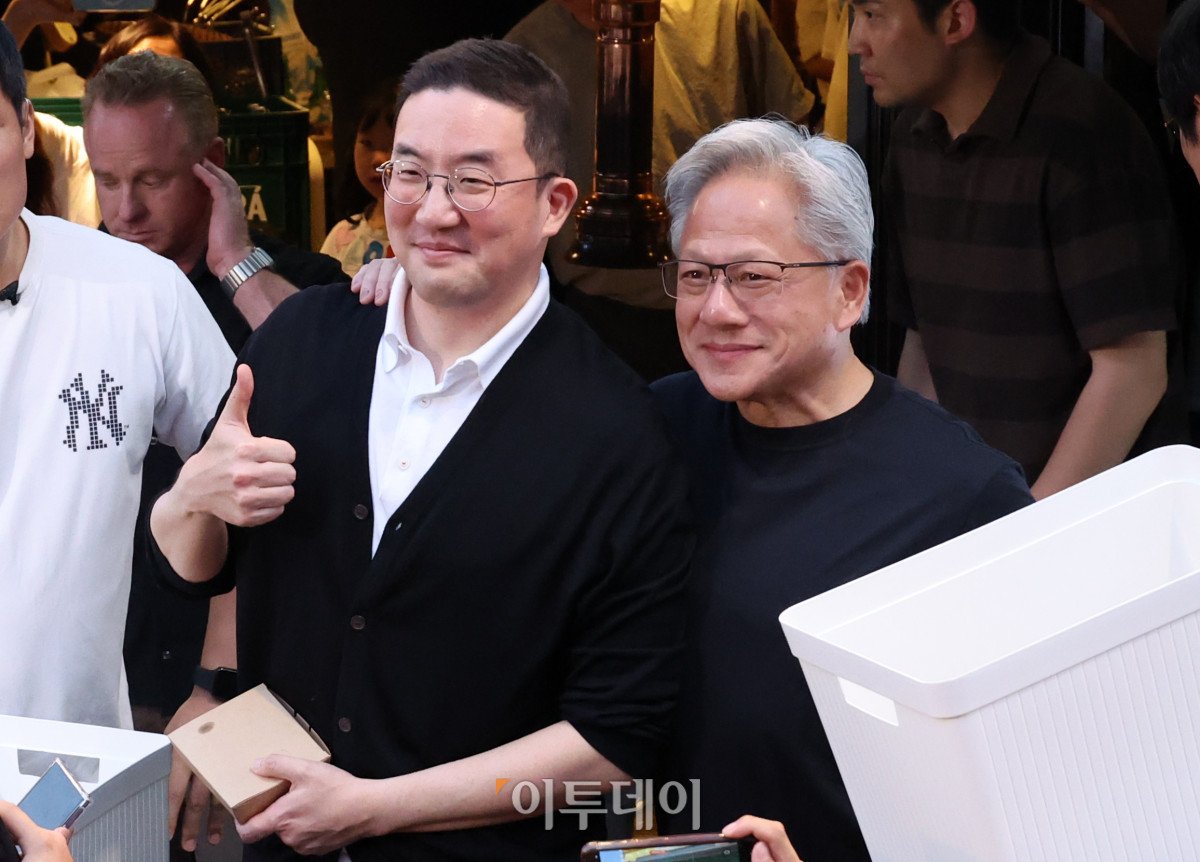 ▲젠슨 황 엔비디아 최고경영자(CEO)가 5일 서울 마포구 홍대 인근 삼겹살 음식점 '형님 저요'에서 '삼소(삼겹살·소주) 회동’ 중 취재진에게 간식을 나눠주며 구광모 LG그룹 회장과 포즈를 취하고 있다. 고이란 기자 photoeran@