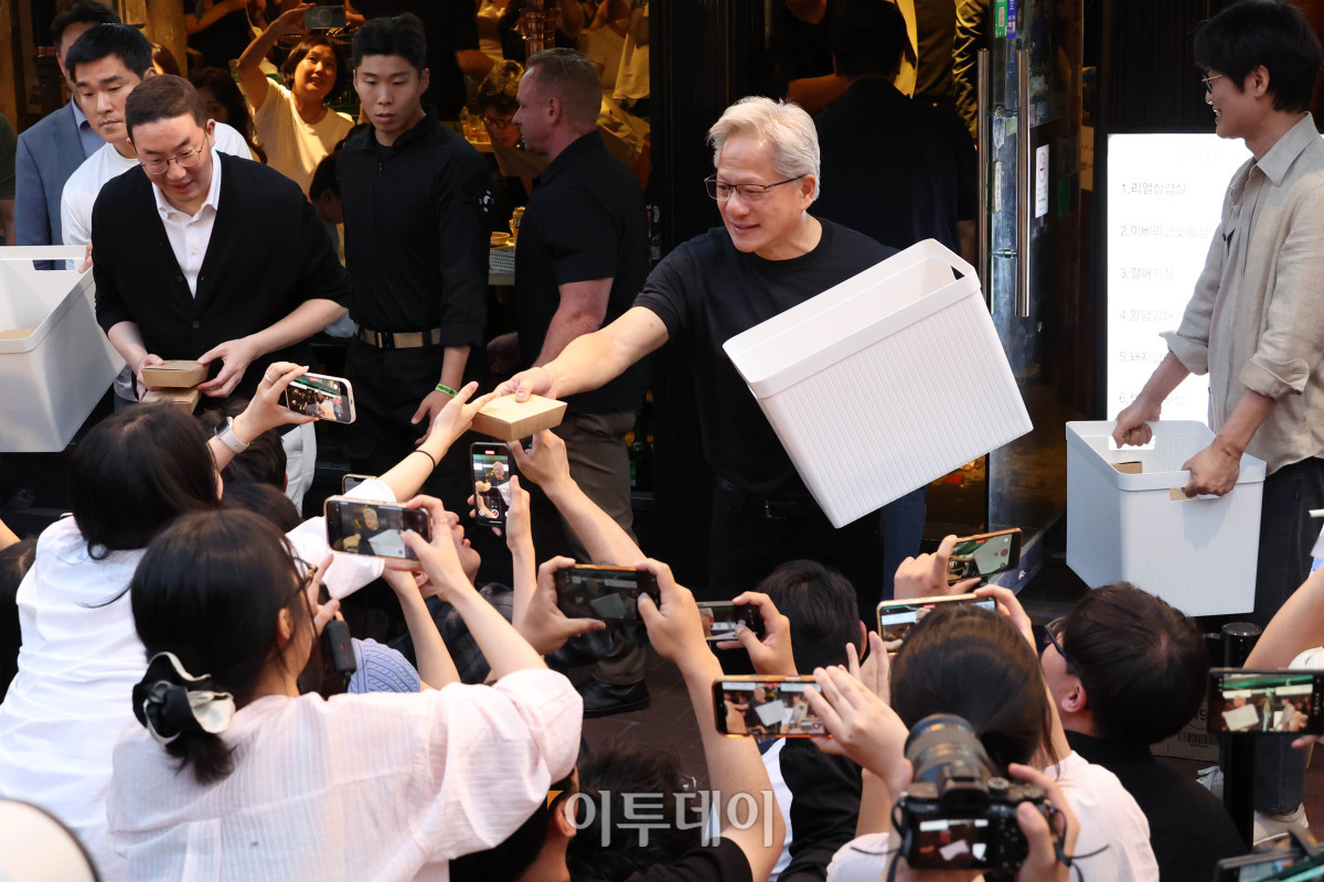 ▲젠슨 황 엔비디아 최고경영자(CEO)가 5일 서울 마포구 홍대 인근 삼겹살 음식점 '형님 저요'에서 최태원 SK그룹 회장, 구광모 LG그룹 회장, 이해진 네이버 의장과 함께 '삼소(삼겹살·소주) 회동’ 중 취재진에게 간식을 나눠주고 있다. 고이란 기자 photoeran@