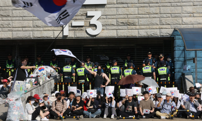 ▲6‧3 지방선거 투표지 부족 사태를 규탄하며 재선거를 요구하는 '잠실 개표소 봉쇄 시위'가 1박 2일째 계속되는 가운데 6일 개표소인 서울 송파구 올림픽공원 핸드볼경기장 앞에서 부정선거를 주장하는 시민들과 보수 성향 유튜버 등이 구호를 외치고 있다. (연합뉴스)
