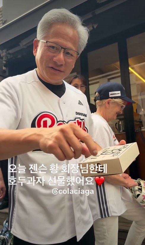 ▲7일 저녁 두산베어스 시구 후 부창제과 호두과자를 선물받은 젠슨 황 CEO (사진=인스타그램 @colaciaga 스토리 캡처)