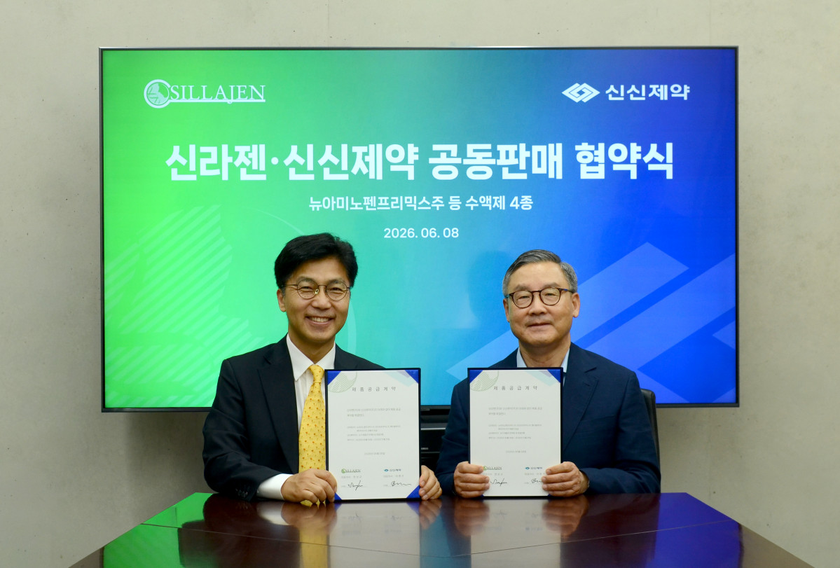 ▲한상규 신라젠 대표이사(왼쪽)와 이병기 신신제약 대표가 협약 후 기념촬영을 하고 있다. (사진제공=신라젠)