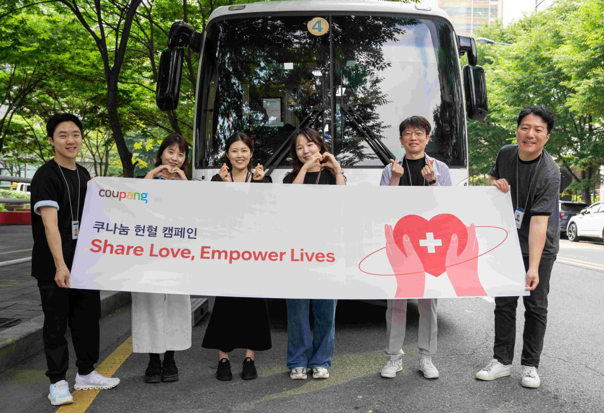 ▲쿠팡 직원들이 서울 잠실 사옥 근처에 마련된 헌혈버스 앞에서 기념 촬영을 하고 있다. (사진제공=쿠팡)