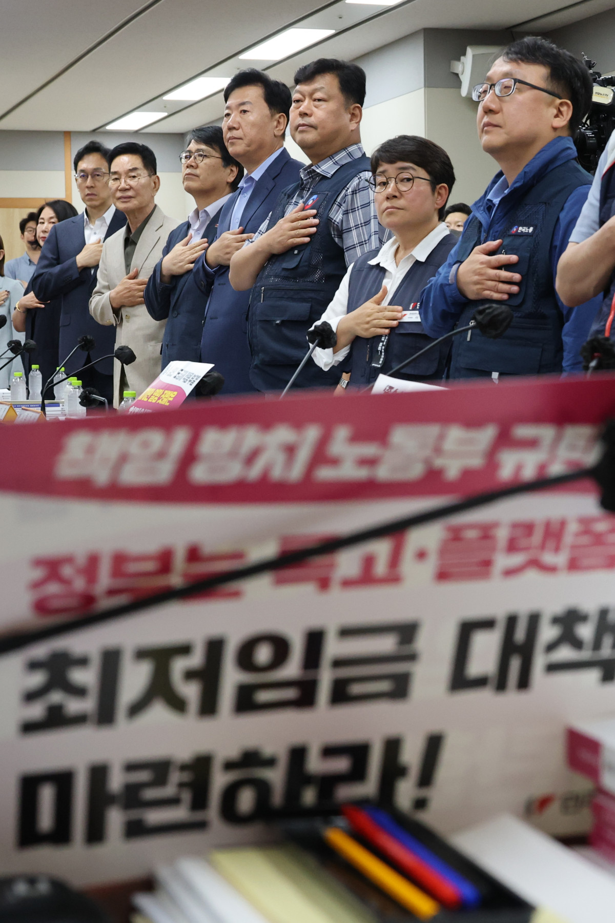 ▲16일 정부세종청사 최저임금위원회에서 열린 제6차 전원회의에서 근로자·사용자·공익 위원들이 국기에 경례하고 있다. (연합뉴스)