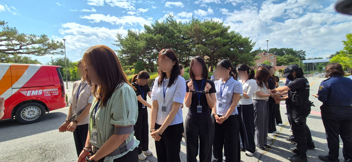 ▲충북 청주시에 있는 청주여자교도소에서 17일 기자들이 수용자 체험을 하고 있다. 벨트형 포승 장치를 착용한 채 교정본부 버스 탑승을 기다리고 있다. (사진 제공=법무부 교정본부)
