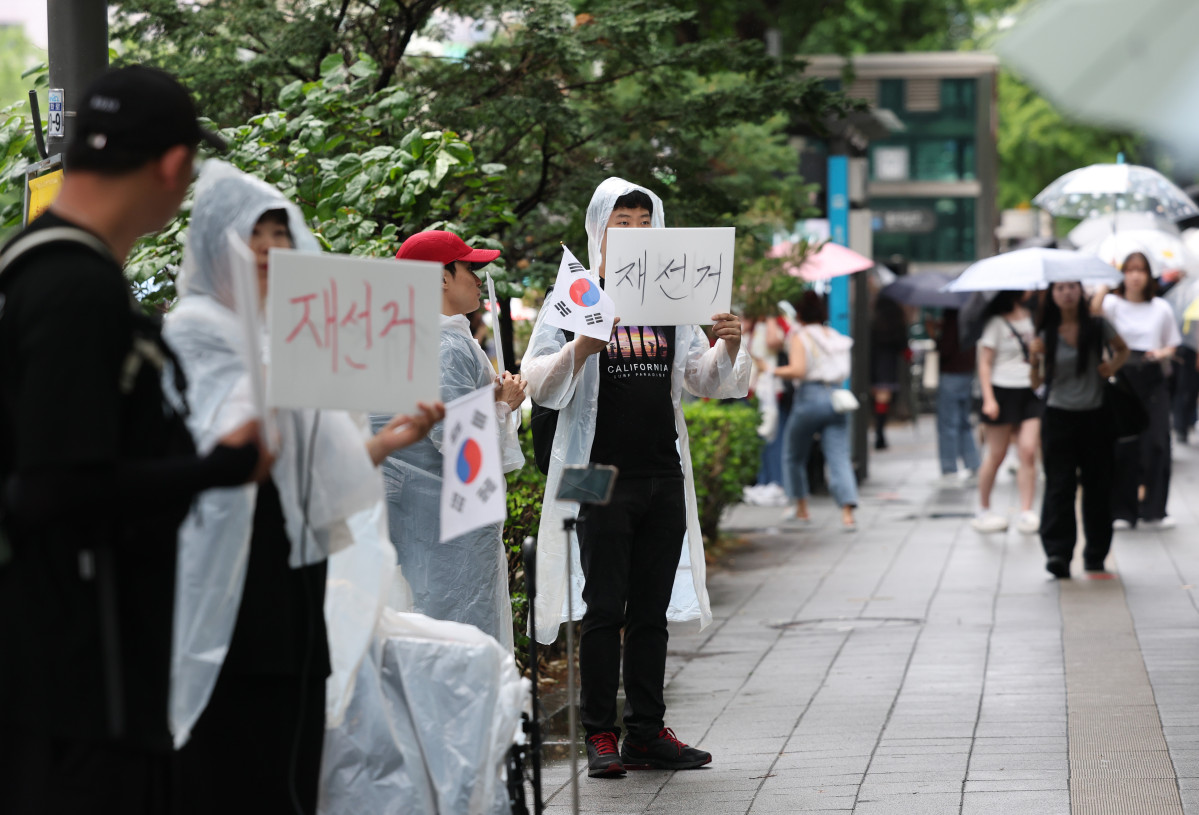 ▲청년단체 회원들이 20일 서울 마포구 홍대입구역 인근에서 재선거를 요구하며 손팻말을 들고 있다. (연합뉴스)
