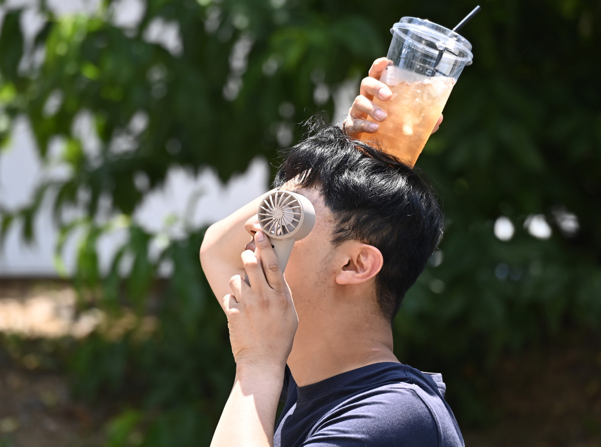▲연일 무더위가 이어지고 있는 17일 경기 수원시 팔달구 인계동에서 한 시민이 손선풍기와 얼음이 들어있는 음료컵을 머리에 올리며 더위를 식히고 있다. (뉴시스)