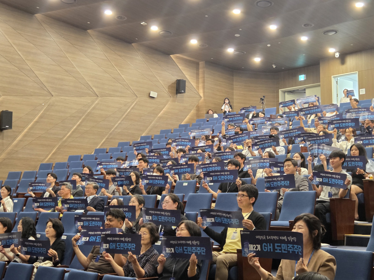 ▲제2기 GH 도민주주단 '기회수도파트너스' 위촉자 100명이 24일 출범식에서 손팻말을 들고 기념촬영을 하고 있다. 이들은 2028년 4월까지 약 2년간 GH 명예주주로 활동한다. (김재학 기자)