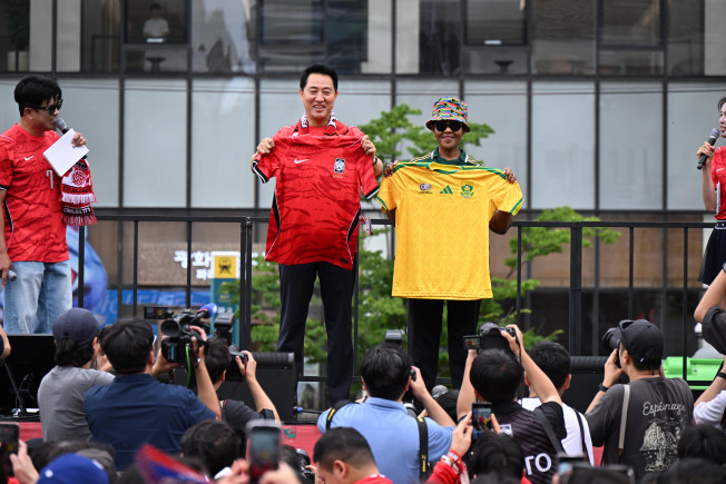 ▲오세훈 서울시장이 25일 광화문광장 일대에서 열린 '2026 북중미 월드컵 대한민국-남아프리카공화국 공동응원전'에서 신디스와 음쿠쿠 주한남아공대사와 유니폼을 교환하고 있다. (사진제공=서울시)
