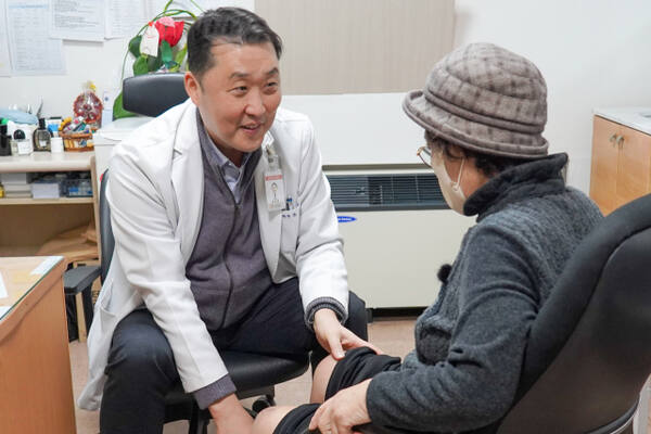 ▲윤성환 이춘택병원장이 진료실에서 환자의 무릎 상태를 직접 살피며 상담하고 있다. 윤 병원장은 21년째 취약계층 무료 인공관절 수술 지원을 이어오며 누적 644명에게 새 걸음을 선물했다. (이춘택병원)