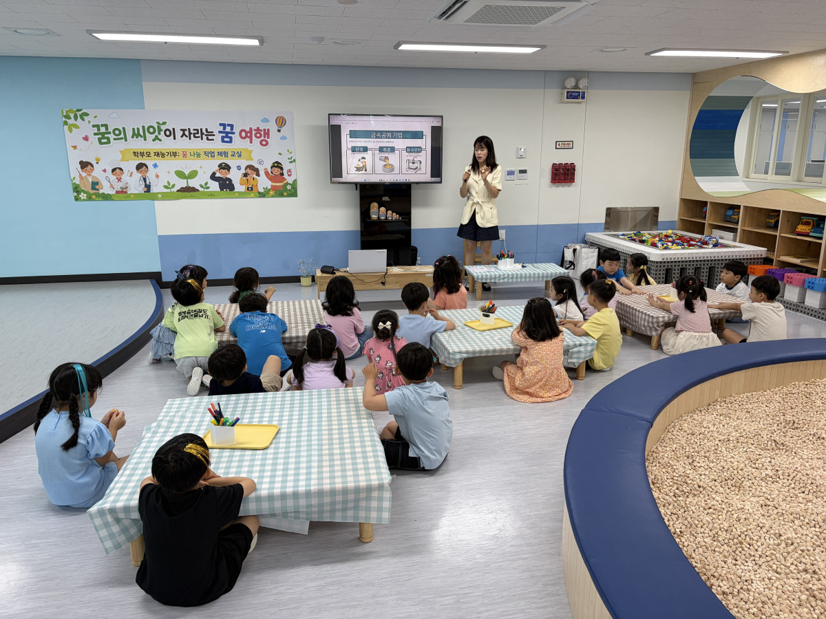 ▲금속공예가 학부모가 5세 반 일일 교사로 물빛나래유치원 교실을 찾아 '금속공예 기법' 슬라이드를 화면에 띄워놓고 탄조·주조·3D프린팅 과정을 아이들 눈높이에 맞춰 설명하고 있다. 손을 들어 설명하는 학부모의 눈빛만큼이나 아이들의 눈도 반짝였다. (물빛나래유치원)