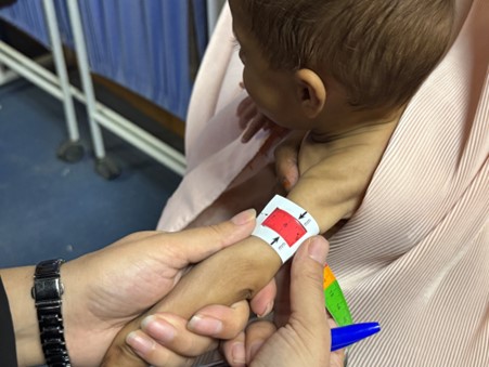 ▲칸다하르 소재 치료식 센터에서 국경없는의사회 간호사가 뮤악 밴드를 이용해 아동의 영양 상태를 측정하고 있다. (국경없는의사회 제공)