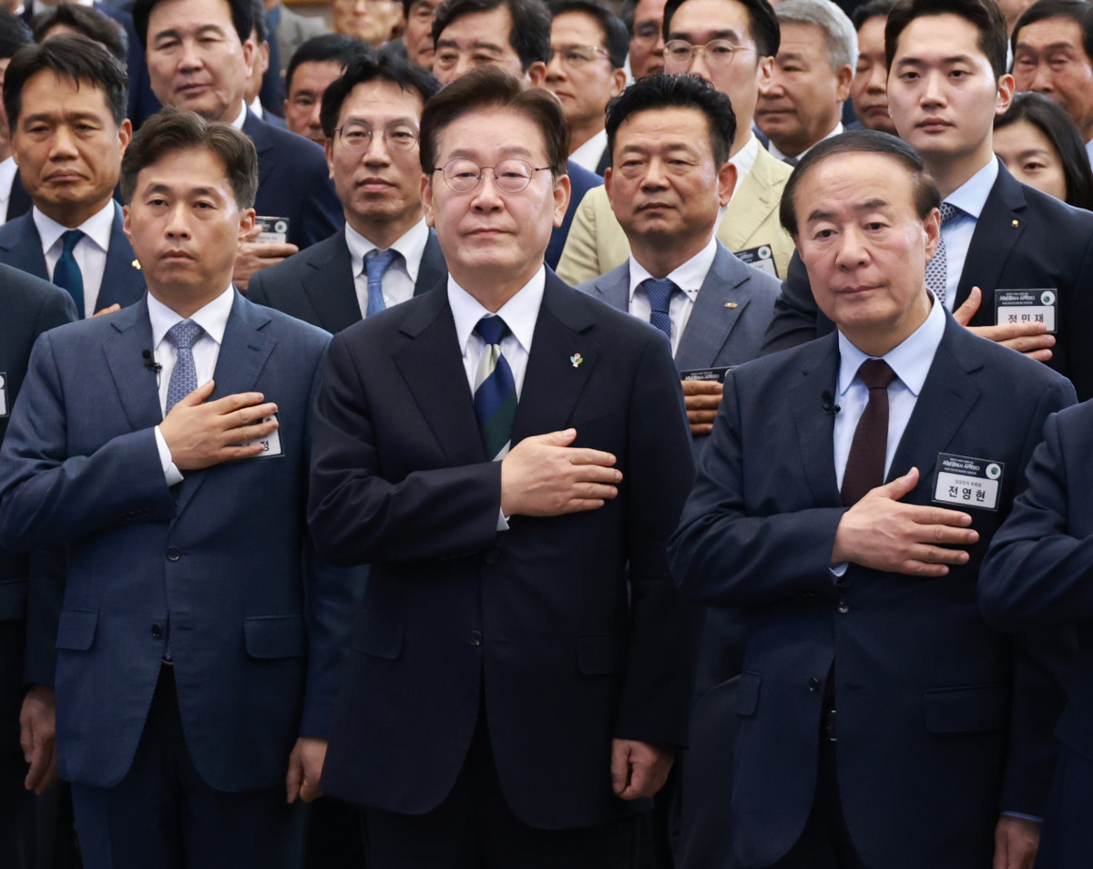 ▲이재명 대통령이 30일 광주 김대중컨벤션센터에서 열린 서남권 첨단산업 발전비전 국민보고회에서 국민의례를 하고 있다. 왼쪽부터 곽노정 SK하이닉스 대표, 이재명 대통령, 전영현 삼성전자 부회장. (연합뉴스)
