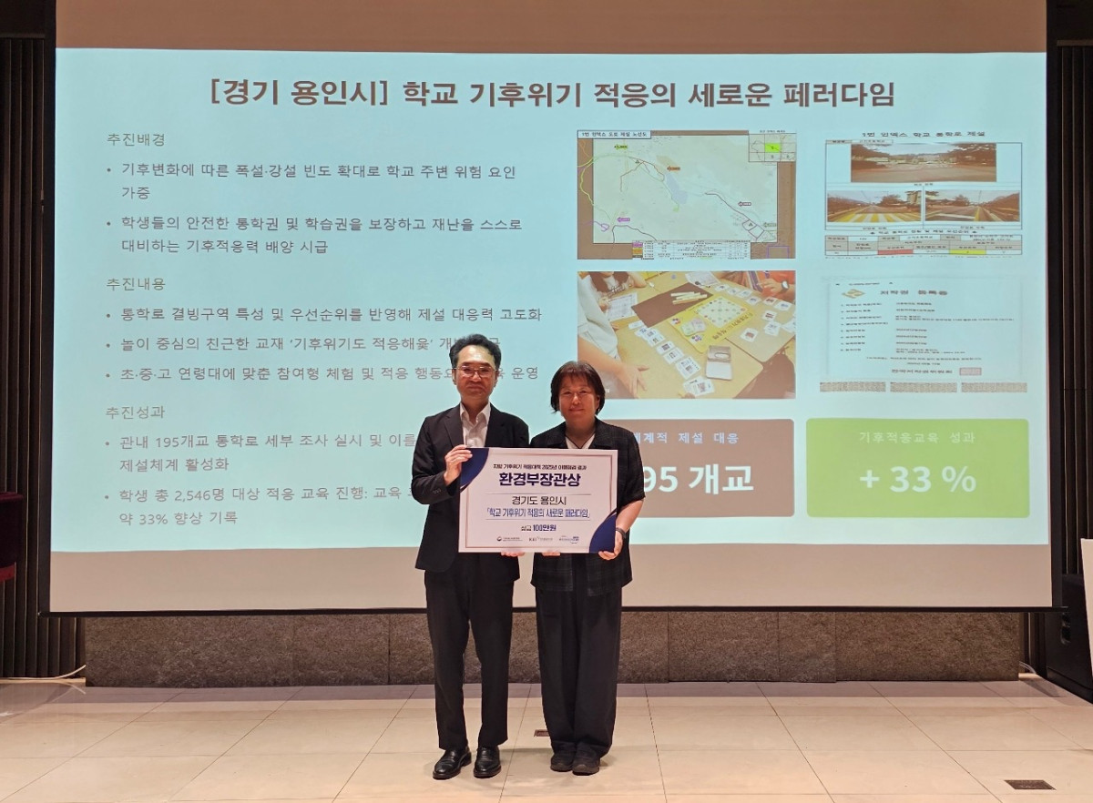 ▲용인특례시 관계자가 기후에너지환경부 장관 표창 상패를 들고 기념촬영을 하고 있다. 배경 화면에는 195개교 통학로 전수 조사와 교육효과 33% 향상 성과가 담겨 있다. 용인특례시는 '학교 기후위기 적응의 새로운 패러다임 구축'으로 전국 최초 2년 연속 우수 지자체에 선정돼 기후에너지환경부 장관 표창을 수상했다. (용인특례시)