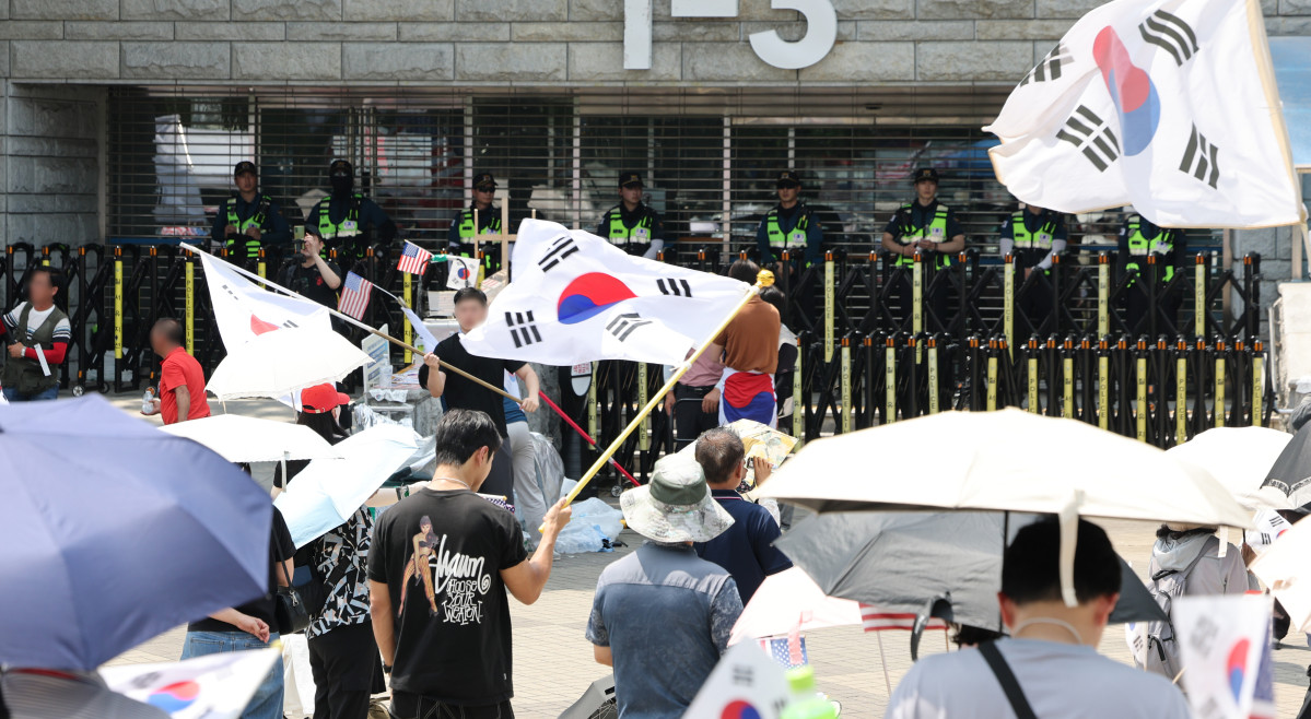 ▲6·3 지방선거 당시 잠실 개표소로 사용된 서울 송파구 올림픽공원 핸드볼경기장 앞에서 지난달 28일 투표용지 부족 사태 규탄 봉쇄 시위 참가자들이 우산을 쓰고 구호를 외치고 있다. (연합뉴스)