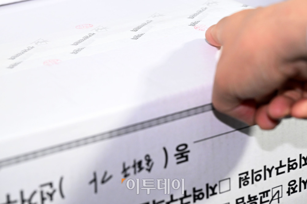▲국회 전국동시지방선거 투표용지 부족 사태 등 국민 참정권 침해 진상규명 및 선거관리 개혁을 위한 국정조사 특별위원회가 2일 오전 서울 송파구 올림픽공원 핸드볼경기장에 대한 현장조사에 나선 가운데 선관위 관계자가 투표지 보관 박스에 찍힌 도장을 가리키고 있다. /국회사진기자단 2026.07.02