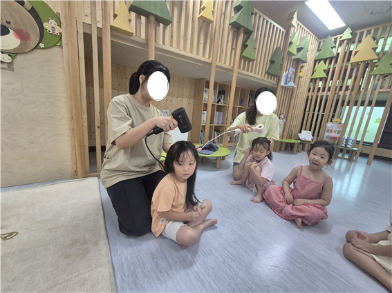 ▲물빛나래유치원 학부모 자원봉사자가 물놀이를 마친 유아의 머리를 말려주고 있다. 학부모회 자원봉사자들은 아이들의 옷 갈아입기와 머리 말리기, 이동 지원 등 세심한 손길이 필요한 자리를 지키며 교육공동체 협력의 가치를 실천했다. (물빛나래유치원)