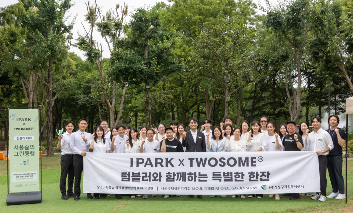 ▲서울국제정원박람회가 열린 서울숲에서 관계자들이 나무가 우거진 공원에서 'IPARK x 투썸플레이스 텀블러와 함께하는 특별한 한잔' 캠페인을 기념해 단체 사진을 촬영하고 있다. (사진제공=투썸플레이스)
