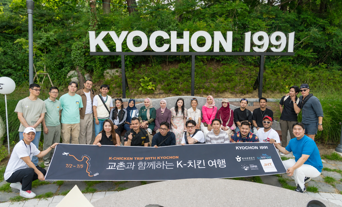 ▲해외 셰프와 요리연구가 등 참가자들이 7월 2일부터 5일까지 열린 교촌과 함께하는 K-치킨 여행 행사에 참여해 KYOCHON 1991 간판 앞에서 단체사진을 촬영하고 있다. (사진제공=교촌에프앤비)