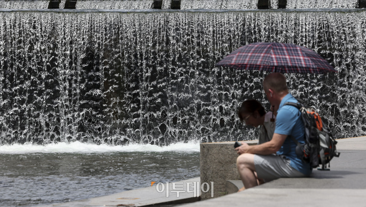 ▲절기상 '소서'를 맞은 7일 서울 청계천을 찾은 관광객들이 더위를 식히고 있다. 이날 기상청은 정체전선이 약해지며 호우특보가 모두 해제된 반면, 오전 11시를 기준으로 전국 대부분 지역에 폭염특보를 발효했다. 고성준 기자 joonko1@