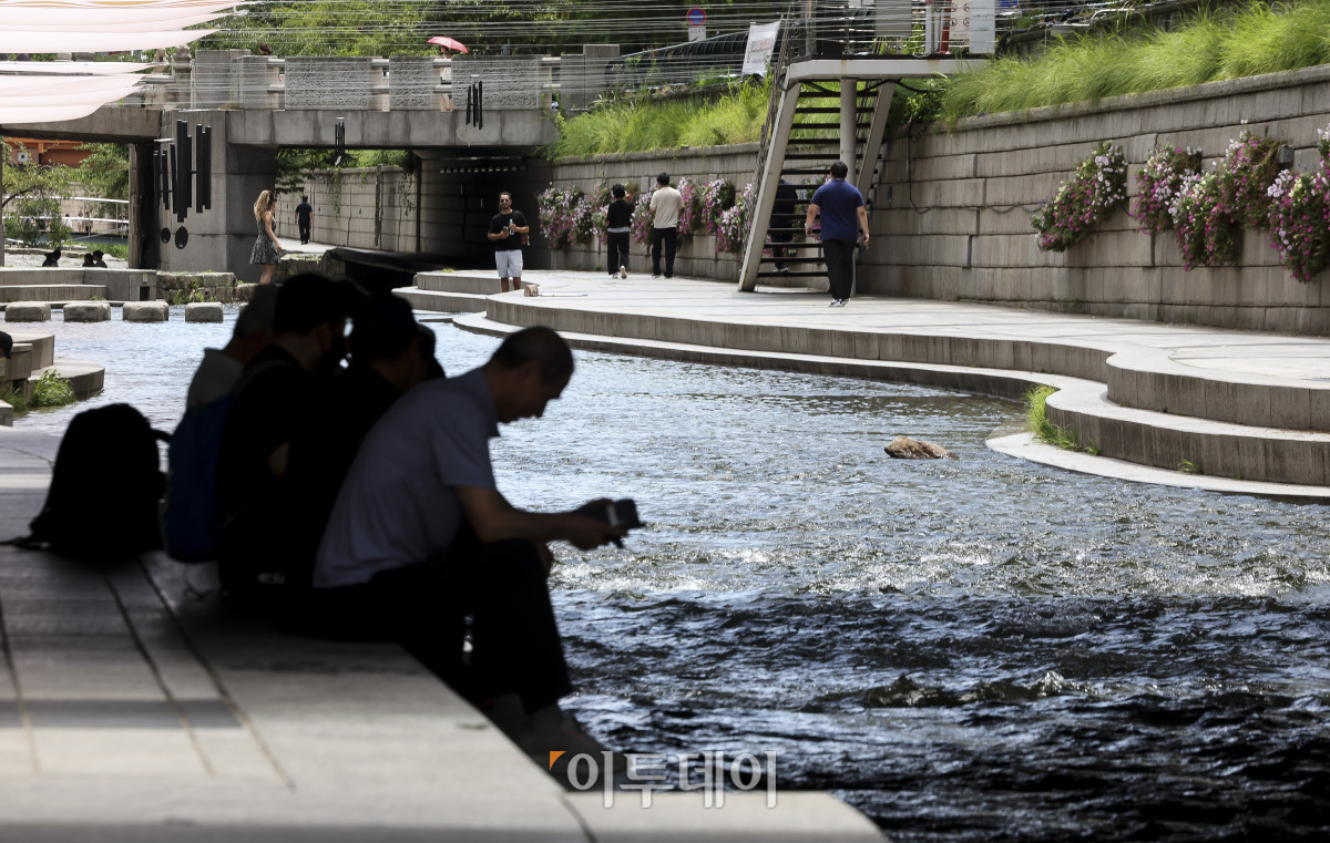 ▲절기상 '소서'를 맞은 7일 서울 청계천을 찾은 시민들이 더위를 식히고 있다. 이날 기상청은 정체전선이 약해지며 호우특보가 모두 해제된 반면, 오전 11시를 기준으로 전국 대부분 지역에 폭염특보를 발효했다. 고성준 기자 joonko1@
