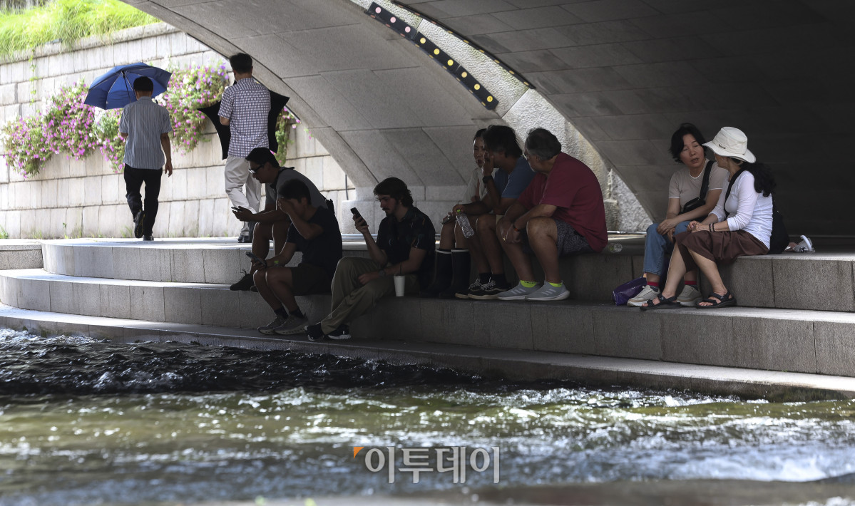 ▲절기상 '소서'를 맞은 7일 서울 청계천을 찾은 시민들이 더위를 식히고 있다. 이날 기상청은 정체전선이 약해지며 호우특보가 모두 해제된 반면, 오전 11시를 기준으로 전국 대부분 지역에 폭염특보를 발효했다. 고성준 기자 joonko1@