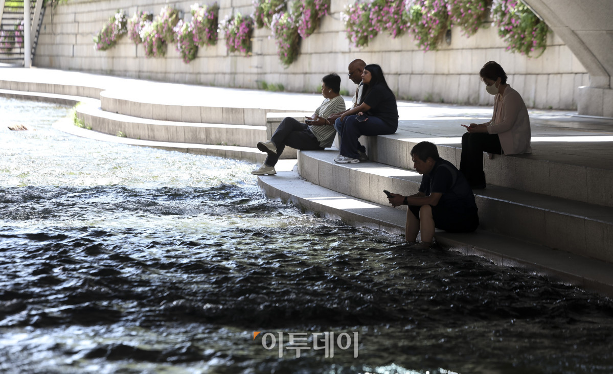 ▲절기상 '소서'를 맞은 7일 서울 청계천을 찾은 시민들이 더위를 식히고 있다. 이날 기상청은 정체전선이 약해지며 호우특보가 모두 해제된 반면, 오전 11시를 기준으로 전국 대부분 지역에 폭염특보를 발효했다. 고성준 기자 joonko1@