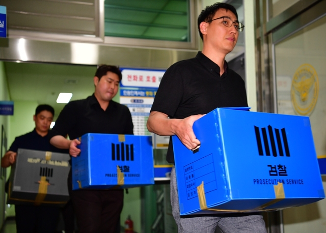 ▲장윤기 여고생 살인사건의 부실수사와 경찰 유착 의혹을 수사하는 광주지검 수사관들이 7일 전남광주통합특별시 광주광산경찰서에 대한 압수수색을 마치고 압수물이 담긴 상자를 들고 나오고 있다 (사진제공=뉴시스)