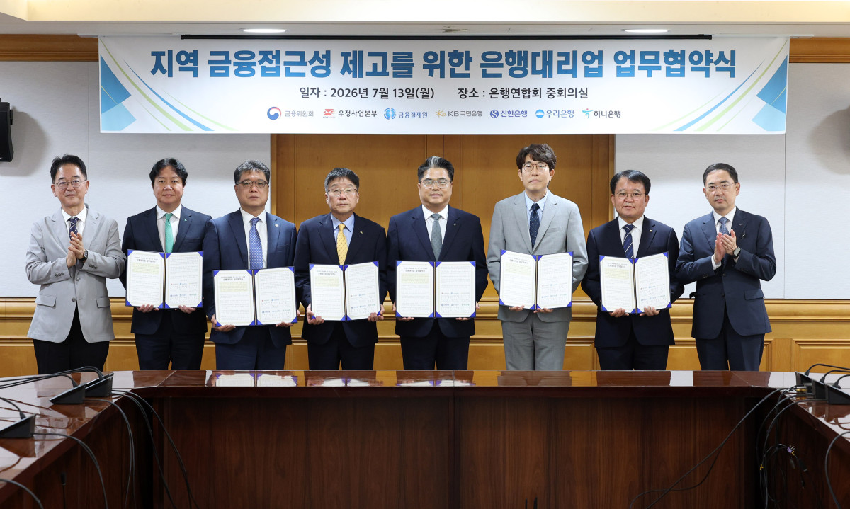 ▲13일 '우체국 은행대리업 시범 운영'에 관한 협약을 체결한 후 참석자들이 기념촬영을 하고 있다. (사진제공=우정사업본부)