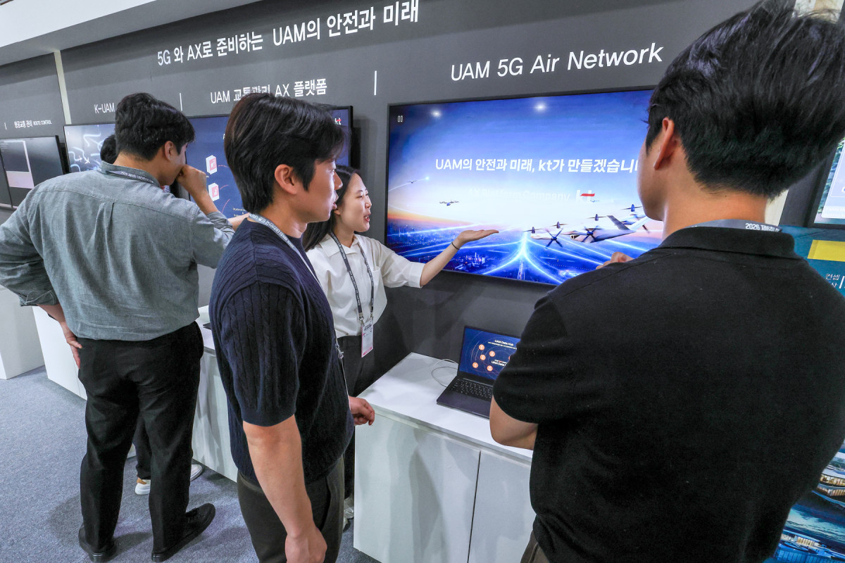 ▲KT가 K-UAM 원팀 소속으로 현대자동차, 현대건설, 인천국제공항공사, 대한한공과 함께 구성한 공동 부스에서 관계자들이 KT의 UAM 기술을 살펴보고 있다. (사진제공=KT)