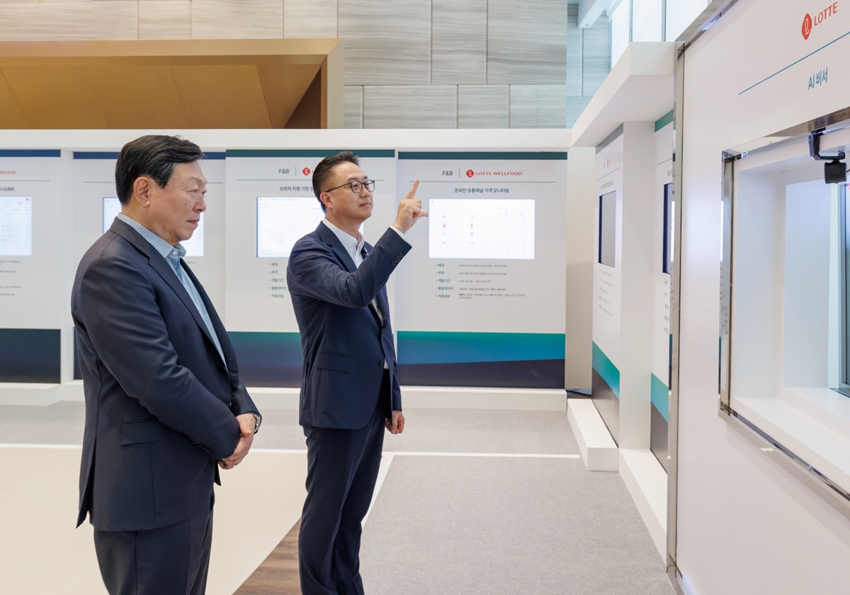 ▲신동빈 롯데 회장(왼쪽)이 15일 롯데월드타워에서 열린 '2026 하반기 VCM'에 앞서 황민재 롯데지주 경영혁신실장으로부터 음성과 모션 인식 기반 'AI 비서'에 대한 설명을 듣고 있다. (사진제공=롯데그룹)