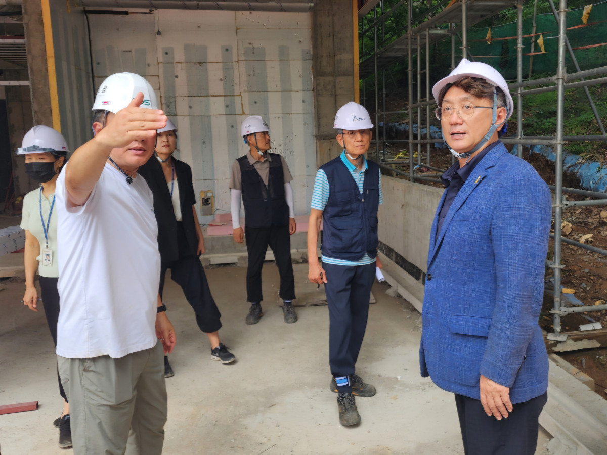 ▲이교우 용인특례시의원(오른쪽)이 7월 14일 수지구 신봉동 도서관 건립 공사 현장을 방문해 관계자로부터 공사 추진 상황을 보고받으며 안전관리 실태를 점검하고 있다. (이교우 용인특례시의원)