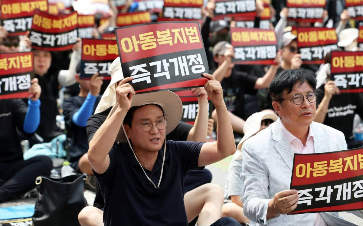 ▲안민석 경기도교육감이 제헌절인 17일 아동복지법 개정을 촉구하는 교사 집회에 참석해 '아동복지법 즉각 개정' 피켓을 들고 교사들과 함께 구호를 외치고 있다. (안민석 경기도교육감 페이스북)