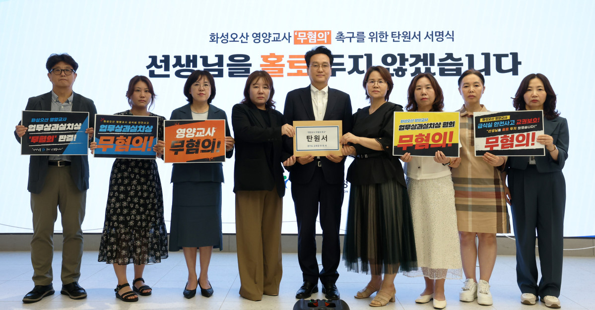 ▲안민석 경기도교육감이 20일 화성·오산 지역 중학교 급식실 안전사고로 수사를 받고 있는 영양교사의 무혐의를 촉구하는 탄원서 서명식에서 참석자들과 함께 탄원서를 들어 보이고 있다. (경기도교육청)
