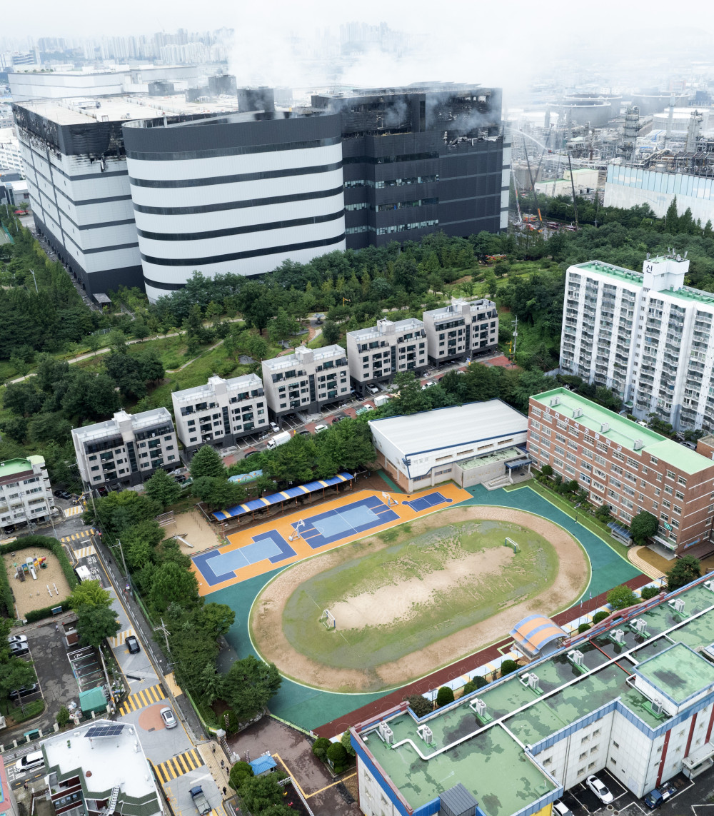 ▲20일 인천 서해구 석남동 쿠팡 물류센터 화재로 임시 휴교한 신석초등학교(아래) 뒤로 물류센터 화재 연기가 피어오르고 있다. (연합뉴스)