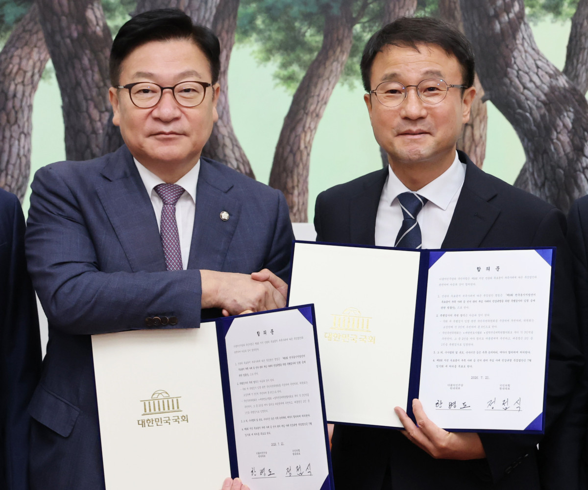 ▲더불어민주당 한병도 대표 직무대행 겸 원내대표(오른쪽)와 국민의힘 정점식 원내대표가 21일 국회 운영위원장실에서 선관위 투표용지 부족 사태에 따른 특검법안 합의문에 서명한 뒤 악수하며 기념 촬영을 하고 있다. (연합뉴스)