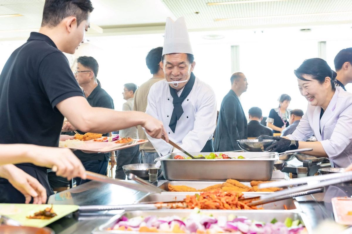 ▲이재준 수원특례시장이 중복을 앞둔 23일 수원시청 구내식당에서 조리복과 조리모를 갖춰 입고 직원들에게 음식을 배식하고 있다. (수원특례시)
